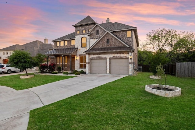 view of front facade with driveway, a standing seam roof, metal roof, and a lawn