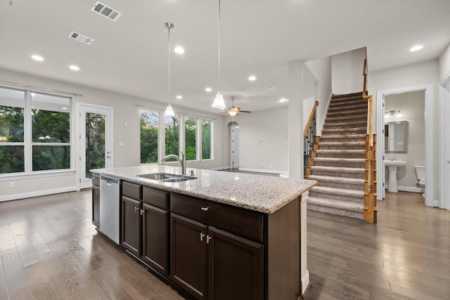 kitchen with a kitchen island with sink, a sink, visible vents, stainless steel dishwasher, and pendant lighting