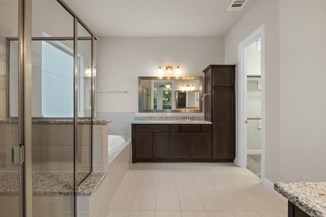 full bathroom with visible vents, a spacious closet, vanity, a shower stall, and a bath