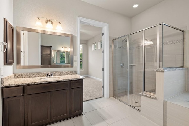 bathroom with recessed lighting, vanity, baseboards, a shower stall, and tile patterned floors