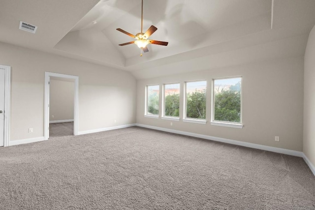 carpeted spare room with lofted ceiling, visible vents, ceiling fan, and baseboards