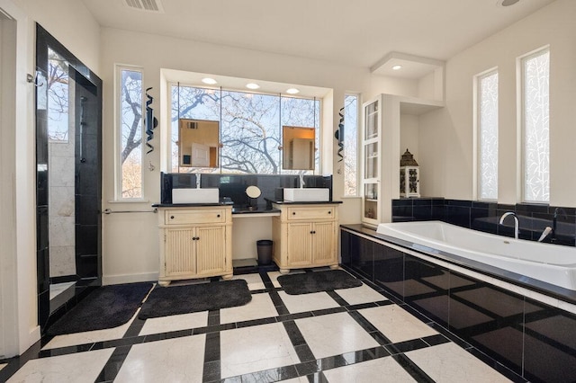 bathroom featuring visible vents, baseboards, vanity, a bath, and recessed lighting