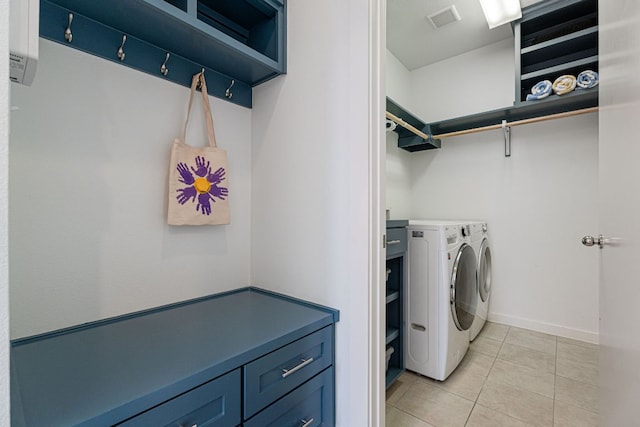 washroom with washing machine and clothes dryer, visible vents, light tile patterned flooring, laundry area, and baseboards