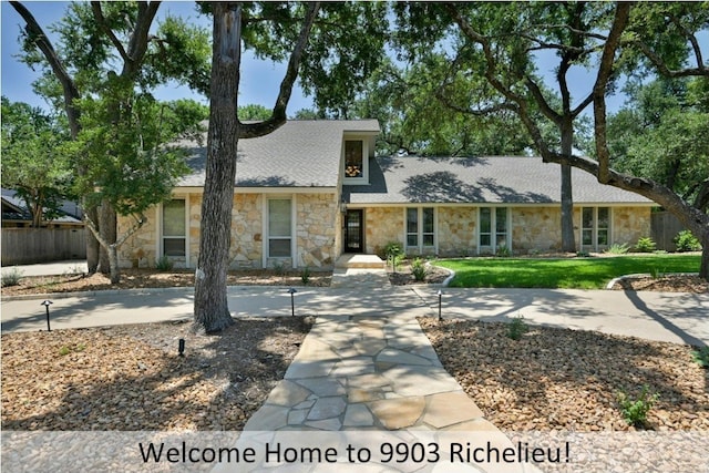 9903 Richelieu Rd, Austin, TX 78750 - view of front facade featuring fence, a shingled roof, stone siding, and a front lawn