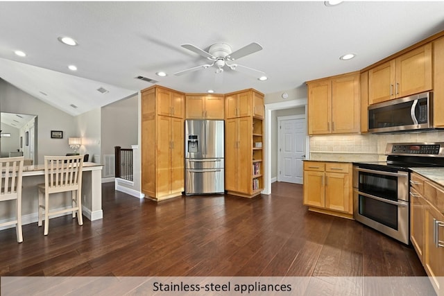 kitchen featuring lofted ceiling, stainless steel appliances, visible vents, backsplash, and dark wood finished floors