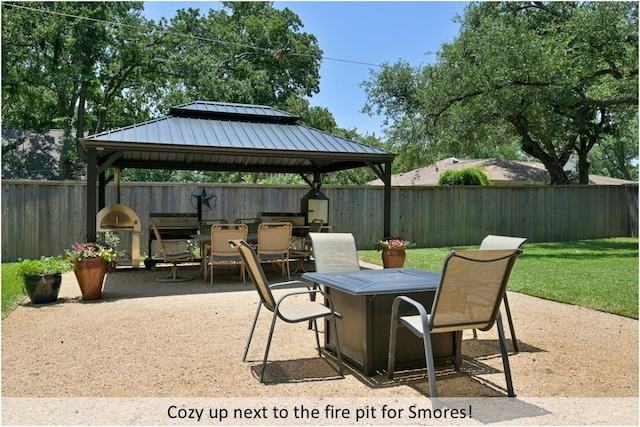 view of patio featuring outdoor dining space, a fenced backyard, and a gazebo