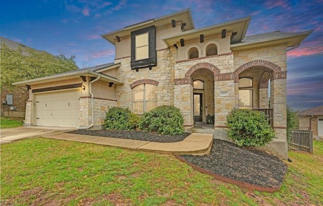 view of front of house featuring a garage, stucco siding, driveway, and a yard