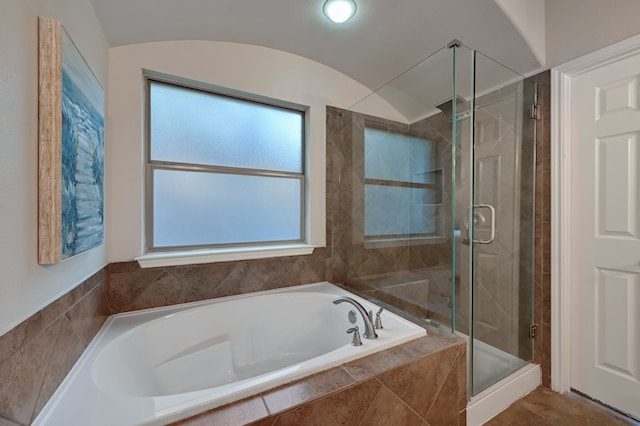 full bath with a shower stall, a garden tub, and lofted ceiling