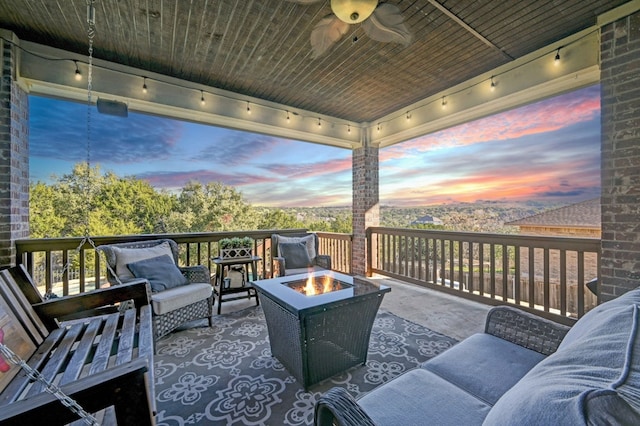 wooden deck with an outdoor living space with a fire pit and ceiling fan