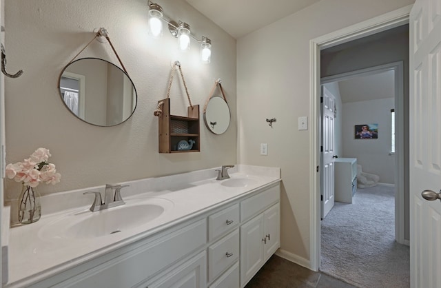 full bath featuring a sink, baseboards, and double vanity