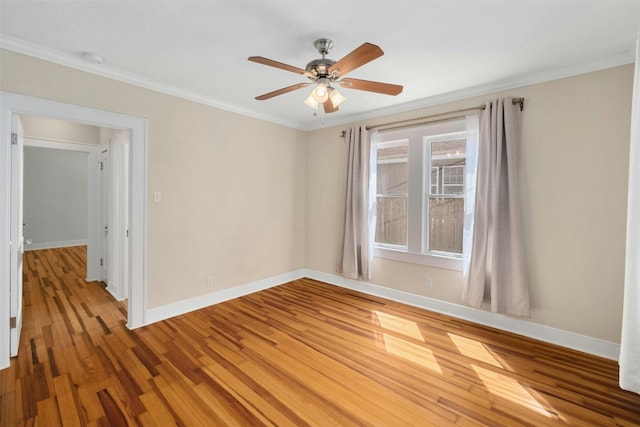 spare room featuring light wood-type flooring, a ceiling fan, baseboards, and crown molding