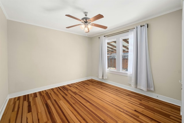 unfurnished room with a ceiling fan, crown molding, baseboards, and wood finished floors