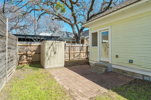 view of yard featuring entry steps, a fenced backyard, a storage shed, an outdoor structure, and a patio area