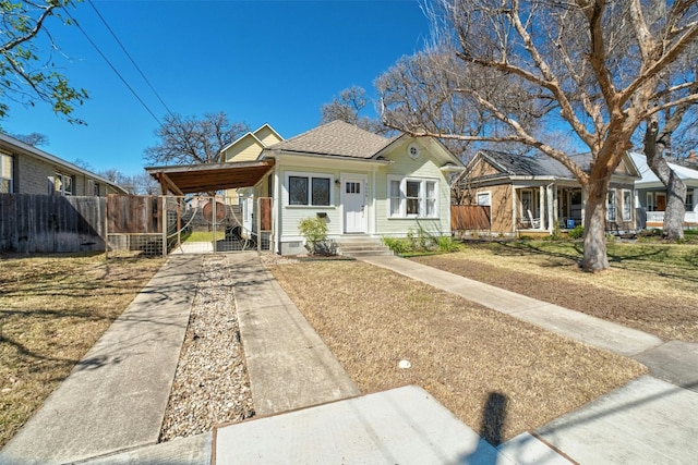 view of front of property with driveway, roof with shingles, a gate, fence, and a carport