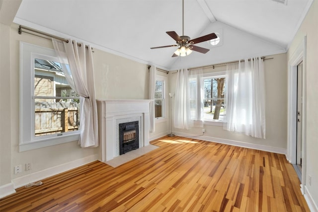 unfurnished living room with vaulted ceiling, wood finished floors, a fireplace with flush hearth, and baseboards