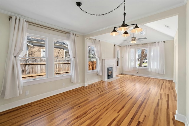 unfurnished living room featuring a fireplace with flush hearth, ornamental molding, baseboards, and wood finished floors