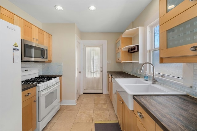 kitchen featuring light tile patterned floors, open shelves, dark countertops, light brown cabinets, and white appliances