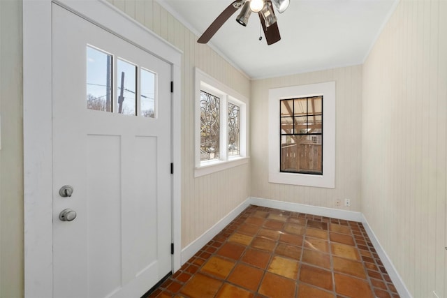 entryway with ornamental molding, ceiling fan, and baseboards