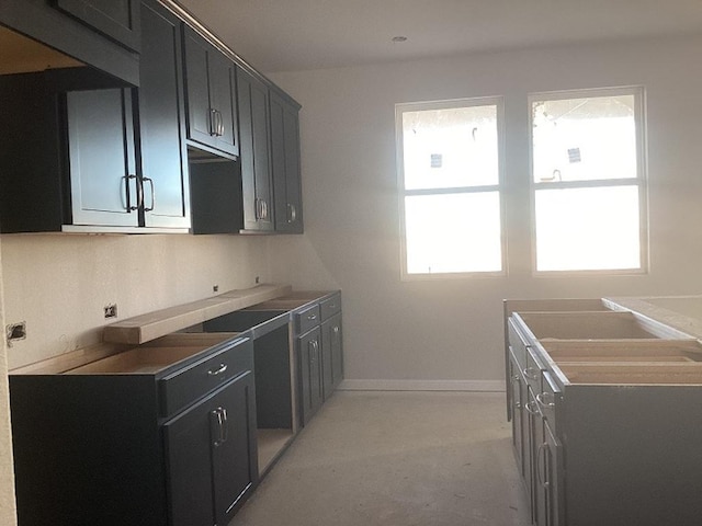 kitchen featuring baseboards and dark cabinets