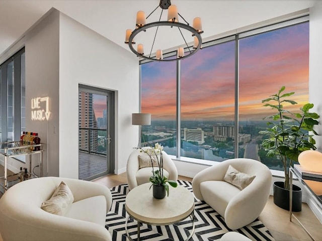 living room with a view of city, wood finished floors, and a chandelier