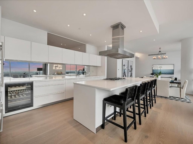 kitchen featuring white cabinetry, light countertops, a large island, modern cabinets, and island exhaust hood