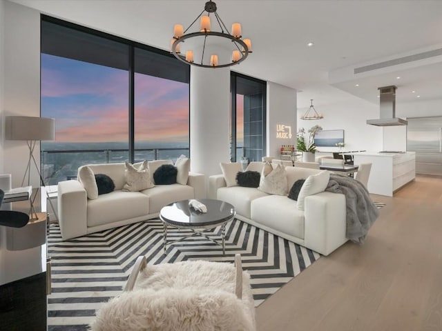 living room with a water view, a chandelier, wood finished floors, and recessed lighting