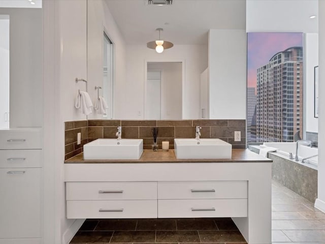 bathroom with tasteful backsplash, a garden tub, a sink, and double vanity