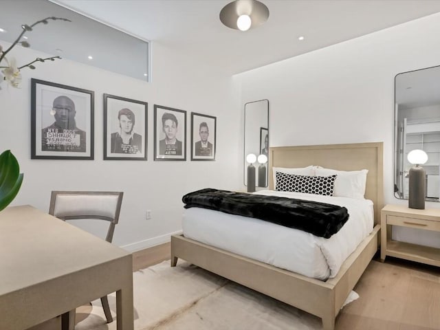 bedroom with light wood-style flooring and baseboards