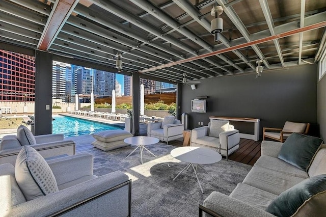 view of patio / terrace featuring a community pool, fence, outdoor lounge area, and a city view