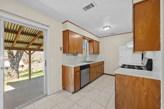 kitchen featuring visible vents, range with gas stovetop, light countertops, stainless steel dishwasher, and a sink