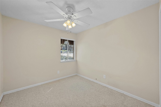 carpeted spare room with ceiling fan, a textured ceiling, and baseboards