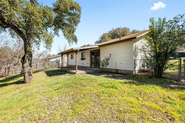 rear view of house with fence, a patio, and a yard