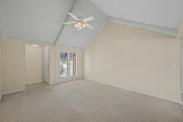 unfurnished room with carpet, ceiling fan, lofted ceiling with beams, and baseboards