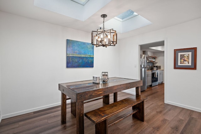 dining room featuring a skylight, a notable chandelier, baseboards, and wood finished floors