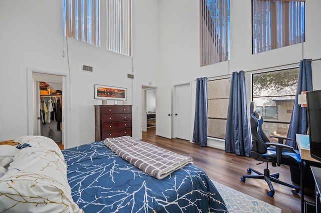 bedroom with visible vents, a spacious closet, and wood finished floors