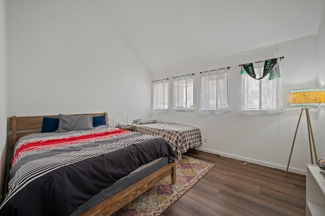 bedroom with lofted ceiling, wood finished floors, and baseboards