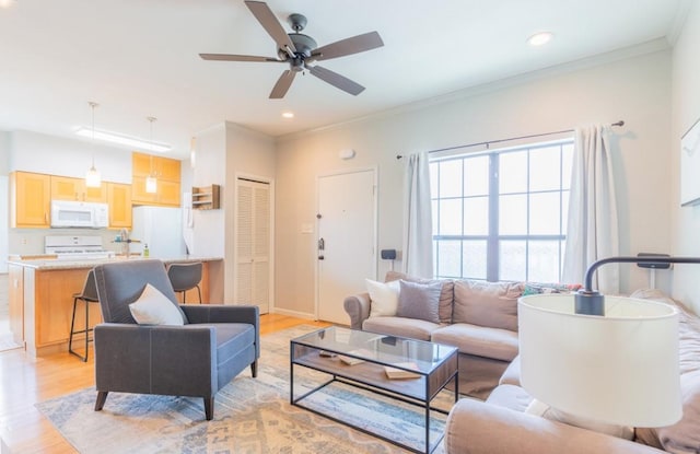 living area featuring ornamental molding, light wood-type flooring, ceiling fan, and recessed lighting