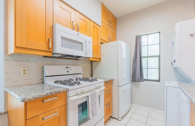 kitchen featuring white appliances, tasteful backsplash, baseboards, light stone counters, and light tile patterned flooring