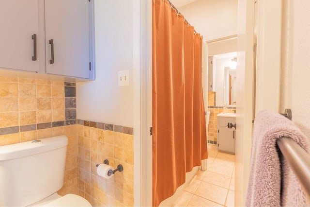 bathroom featuring tile patterned flooring, curtained shower, tile walls, and toilet