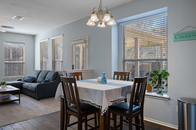 dining room featuring visible vents, dark wood-style flooring, and ceiling fan with notable chandelier