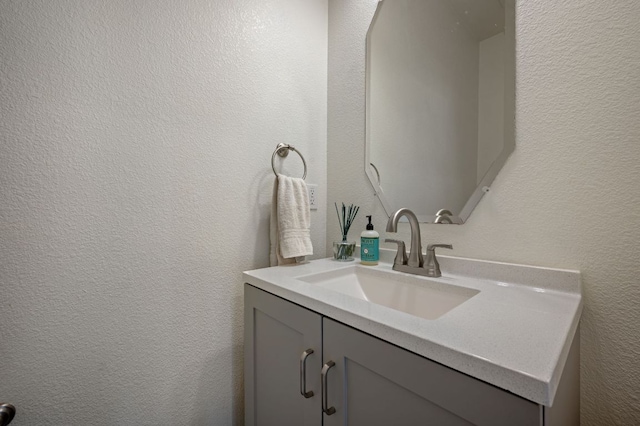 bathroom featuring a textured wall and vanity