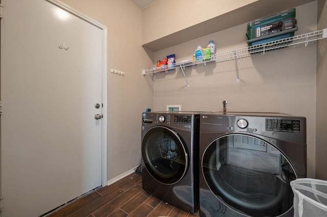 washroom with baseboards, laundry area, washer and clothes dryer, and wood tiled floor