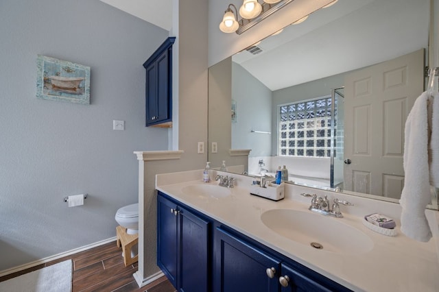 full bathroom featuring toilet, wood tiled floor, double vanity, and a sink