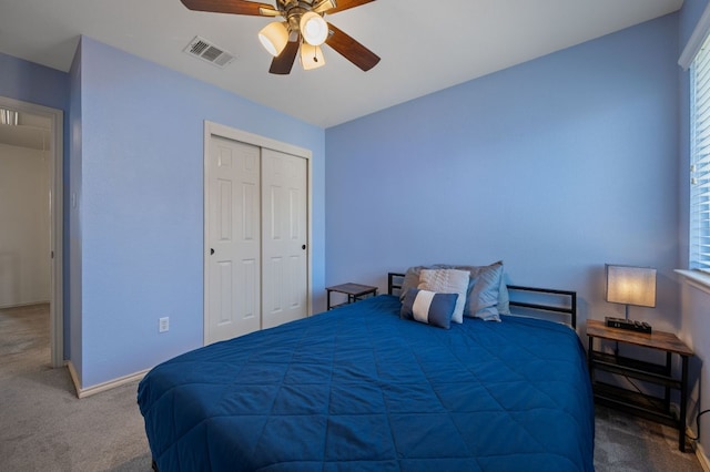 carpeted bedroom featuring a closet, visible vents, ceiling fan, and multiple windows