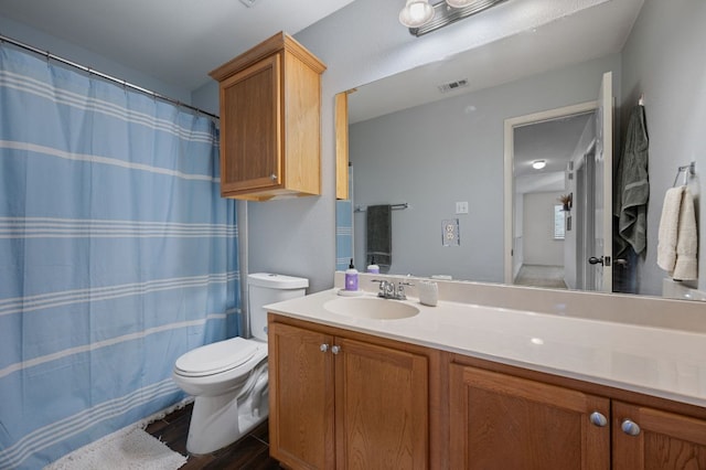 bathroom featuring toilet, a shower with curtain, visible vents, and vanity