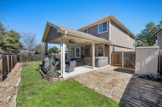 back of property featuring a ceiling fan, a yard, a fenced backyard, and a patio