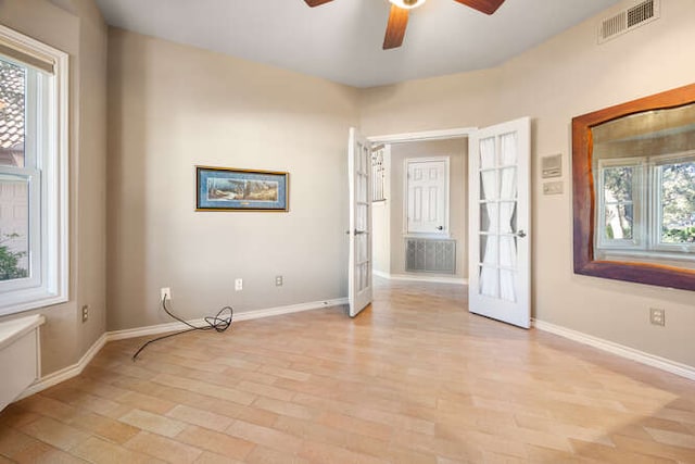 spare room with a healthy amount of sunlight, visible vents, baseboards, and light wood finished floors