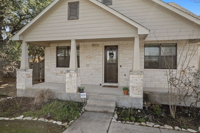 view of front facade with covered porch and stone siding