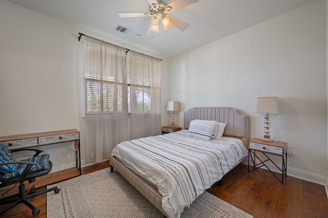 bedroom featuring ceiling fan, wood finished floors, visible vents, and baseboards