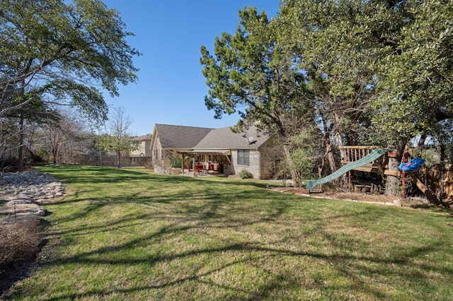 view of front of home featuring a patio area, a playground, fence, and a front yard